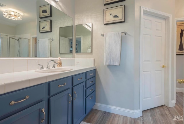 bathroom featuring vanity, hardwood / wood-style flooring, and walk in shower