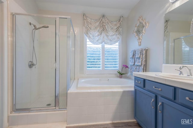 bathroom with vanity and shower with separate bathtub