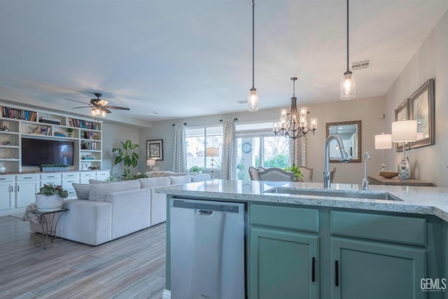 kitchen with hanging light fixtures, sink, stainless steel dishwasher, and light stone counters