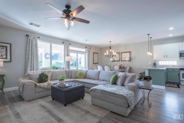 living room featuring dark hardwood / wood-style floors and ceiling fan with notable chandelier