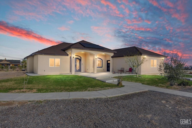 28124 Mustang Ave, Taft, CA 93268 - ranch-style house with solar panels, a lawn, and stucco siding