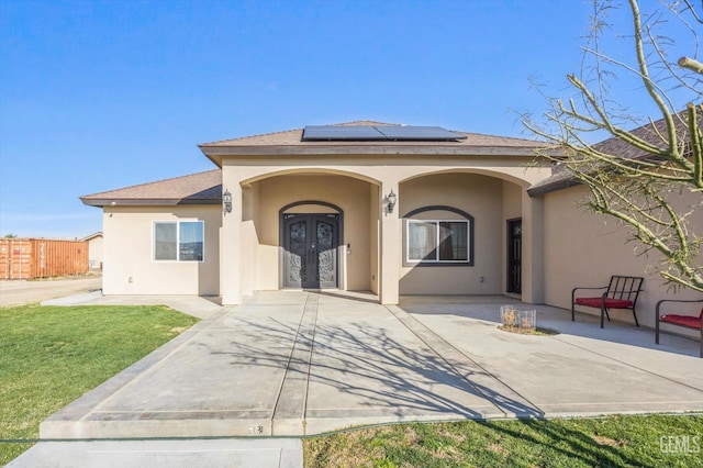 28124 Mustang Ave, Taft, CA 93268 - view of exterior entry featuring french doors, stucco siding, and roof mounted solar panels