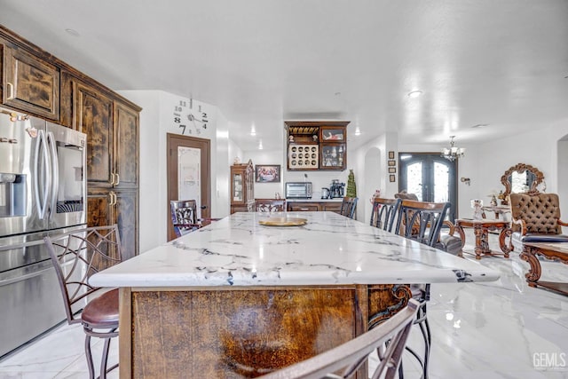 28124 Mustang Ave, Taft, CA 93268 - kitchen with stainless steel refrigerator with ice dispenser, arched walkways, french doors, light marble finish floors, and a kitchen island