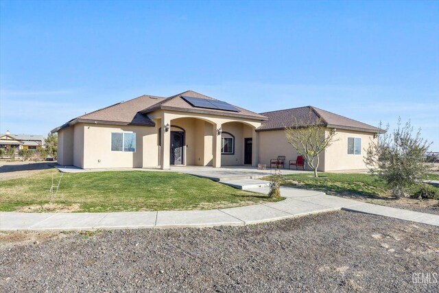 28124 Mustang Ave, Taft, CA 93268 - view of front of home featuring stucco siding, roof mounted solar panels, a front lawn, and a shingled roof