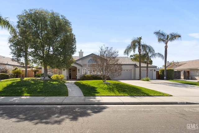 view of front of house featuring stucco siding, fence, a garage, driveway, and a front lawn