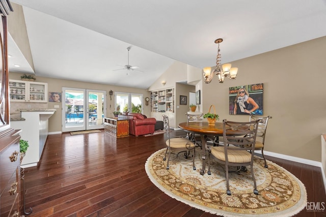 dining room featuring lofted ceiling, ceiling fan with notable chandelier, wood finished floors, and baseboards