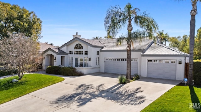 view of front of home featuring an attached garage, driveway, stucco siding, a chimney, and a front yard