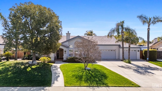 view of front of house featuring concrete driveway, an attached garage, fence, a front lawn, and stucco siding