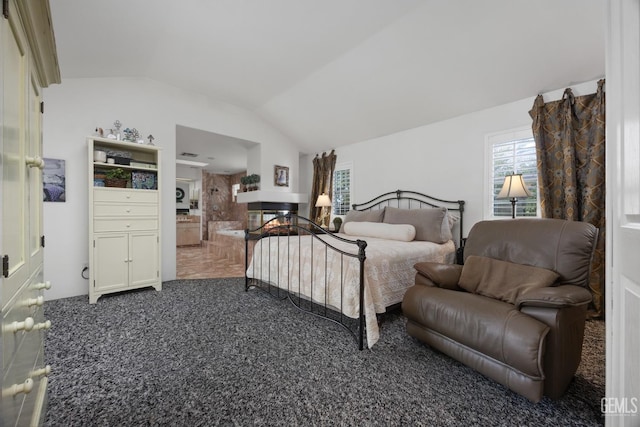 bedroom with lofted ceiling, dark colored carpet, and a multi sided fireplace