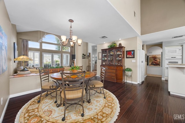 dining room with dark wood finished floors, visible vents, and baseboards