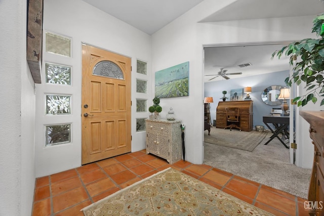 carpeted foyer entrance featuring tile patterned flooring and visible vents