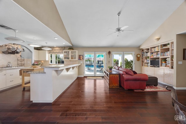 kitchen with light countertops, white cabinetry, ceiling fan, a peninsula, and a kitchen breakfast bar