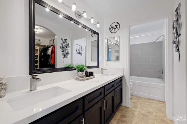 full bathroom featuring double vanity, tile patterned flooring, toilet, and a sink