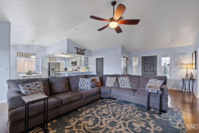 living area featuring lofted ceiling, ceiling fan, baseboards, and wood finished floors