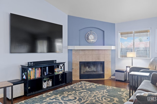 living area featuring a tile fireplace and wood finished floors