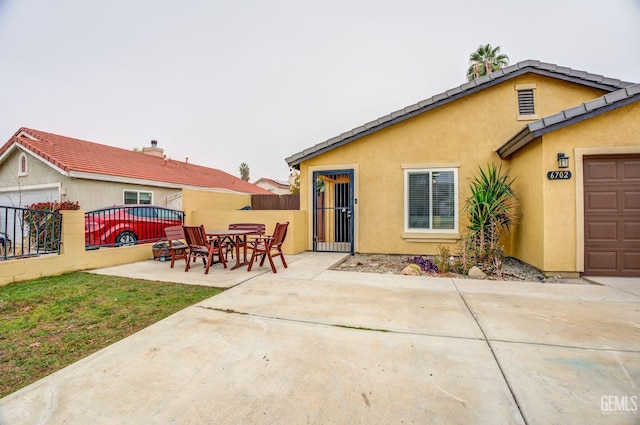 back of house featuring a patio and a garage