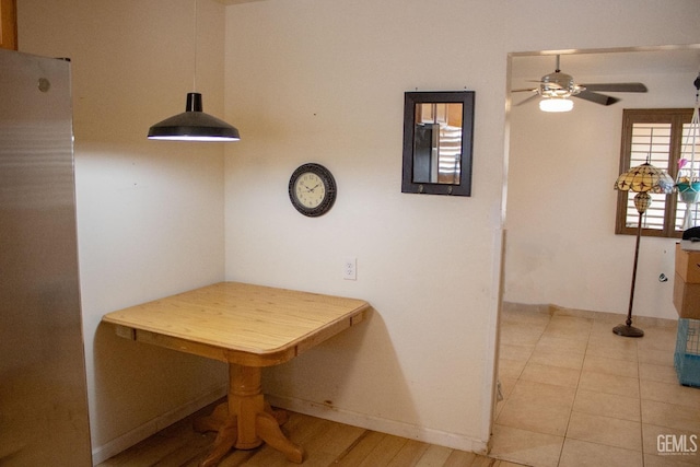 dining space featuring a ceiling fan and baseboards