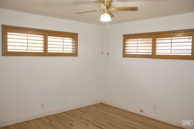 unfurnished room with baseboards, a ceiling fan, a wealth of natural light, and light wood-style floors