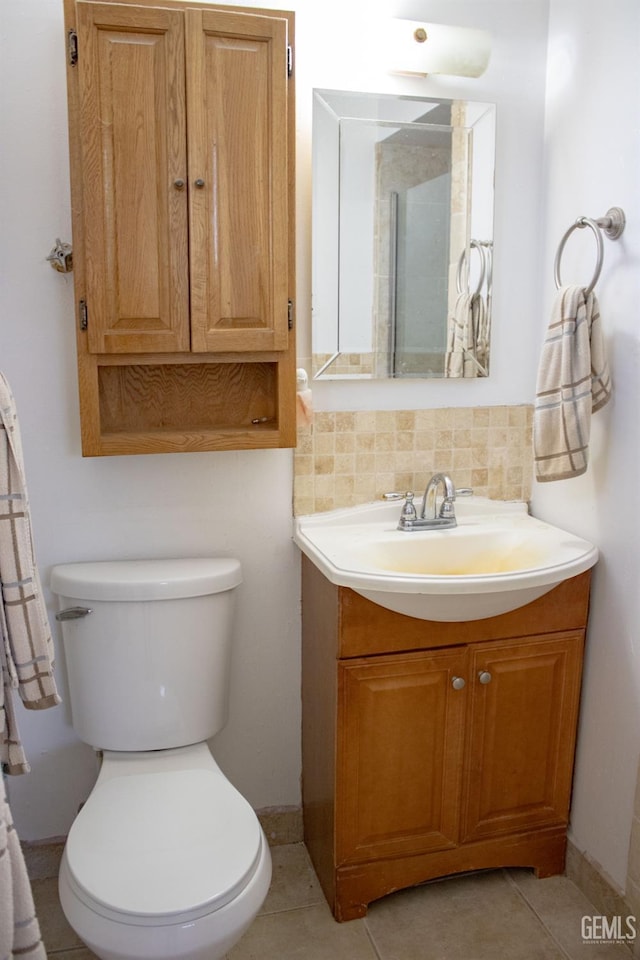 bathroom featuring tasteful backsplash, tile patterned flooring, vanity, and toilet