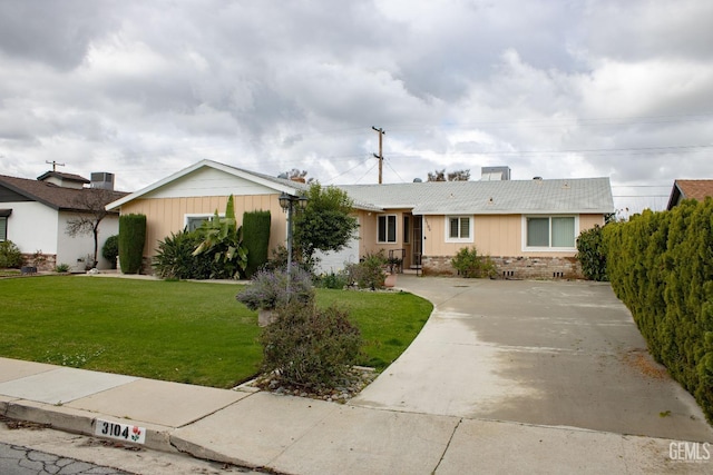 ranch-style home with brick siding, driveway, and a front lawn