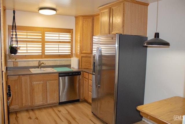 kitchen featuring light brown cabinetry, appliances with stainless steel finishes, a sink, and light wood-style flooring