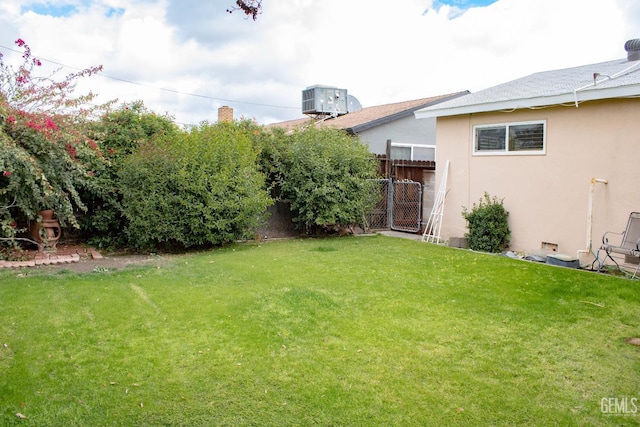 view of yard with fence and central air condition unit