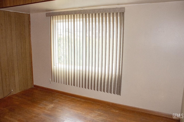 empty room with baseboards and wood finished floors