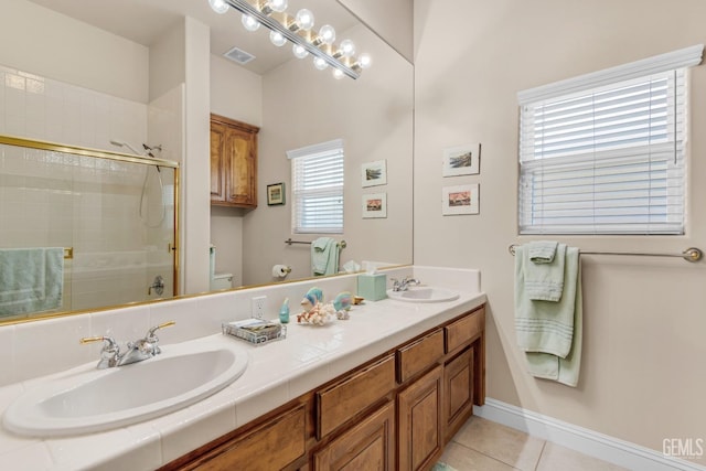 full bath featuring tile patterned floors, a sink, visible vents, and a shower stall