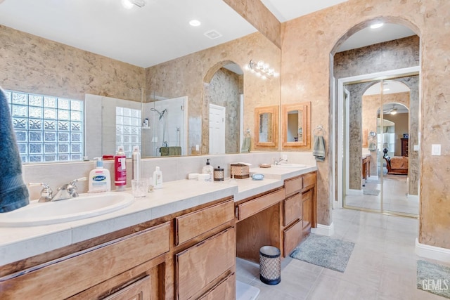 bathroom with double vanity, tile patterned flooring, a sink, and a shower with shower door