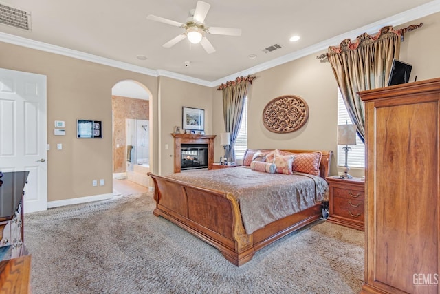 bedroom with ornamental molding, carpet, visible vents, and a glass covered fireplace