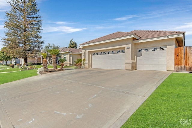 view of front of house with stucco siding, concrete driveway, an attached garage, a front yard, and a tiled roof