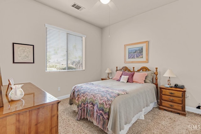 bedroom featuring light colored carpet, ceiling fan, visible vents, and baseboards