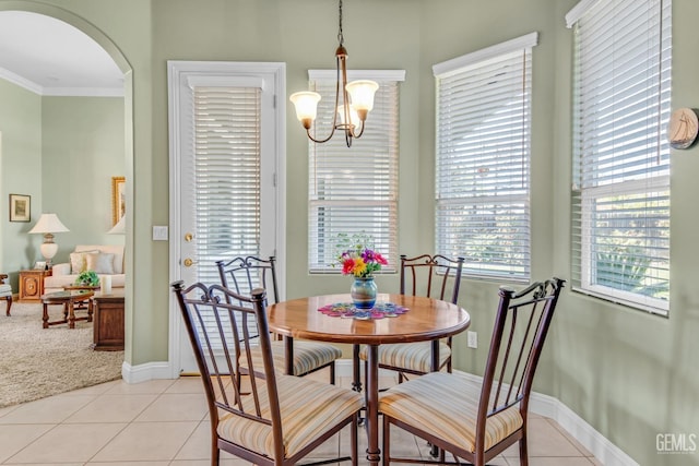 dining space featuring light tile patterned floors, baseboards, arched walkways, and a notable chandelier