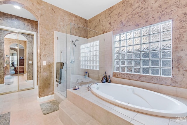 full bathroom with a stall shower, a bath, and tile patterned floors