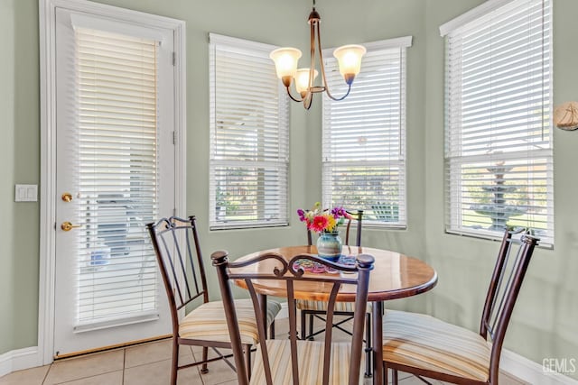 dining room with light tile patterned floors, baseboards, and a chandelier