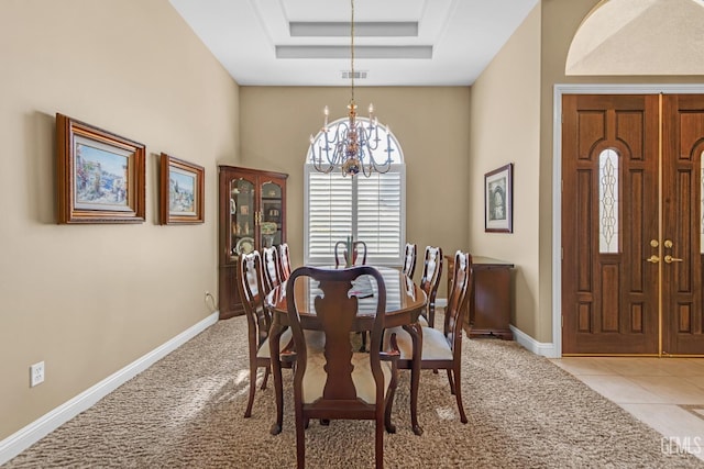 dining room featuring light tile patterned floors, light carpet, baseboards, a raised ceiling, and an inviting chandelier