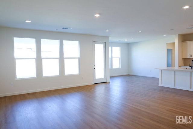 unfurnished living room featuring dark hardwood / wood-style floors and sink