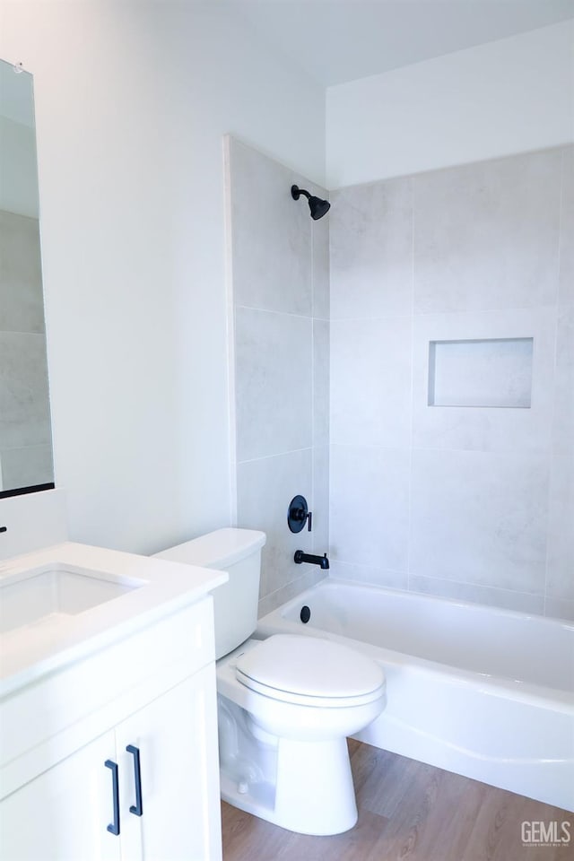 full bathroom featuring vanity, wood-type flooring, toilet, and tiled shower / bath