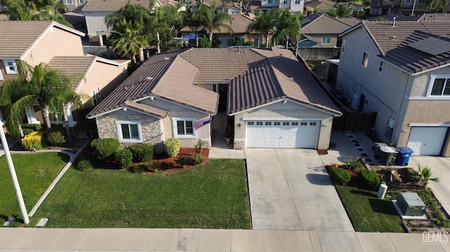 2114 Via Lazio Ave, Delano, CA 93215 - view of front of house with a residential view, concrete driveway, an attached garage, stone siding, and a tile roof