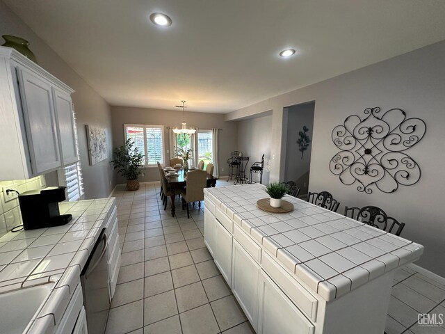 2114 Via Lazio Ave, Delano, CA 93215 - kitchen featuring tile counters, light tile patterned flooring, a chandelier, white cabinets, and recessed lighting