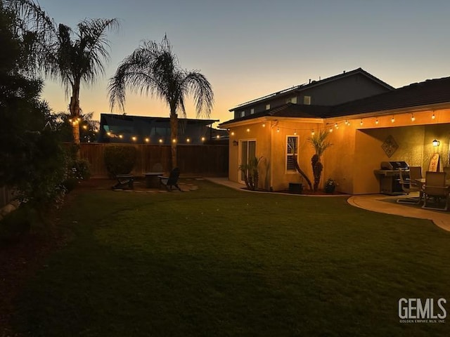 2114 Via Lazio Ave, Delano, CA 93215 - yard at dusk featuring an outdoor fire pit and a patio area