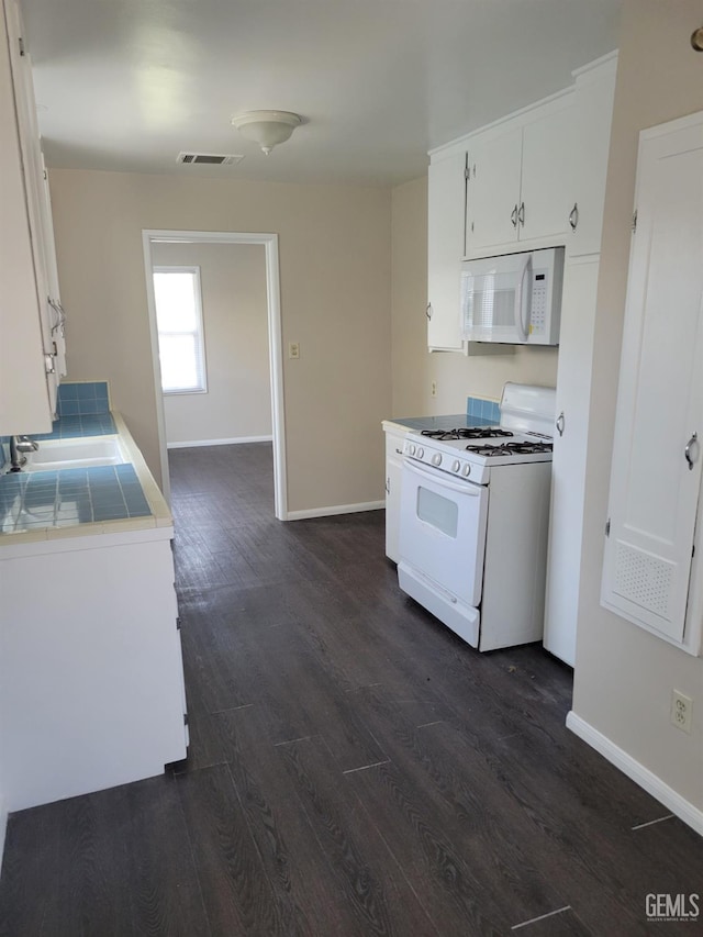 2915 Cedar St, Bakersfield, CA 93301 - kitchen with white appliances, dark wood-type flooring, tile counters, and white cabinetry