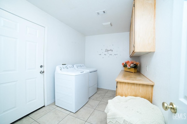 laundry room with cabinets, washing machine and dryer, and light tile patterned floors