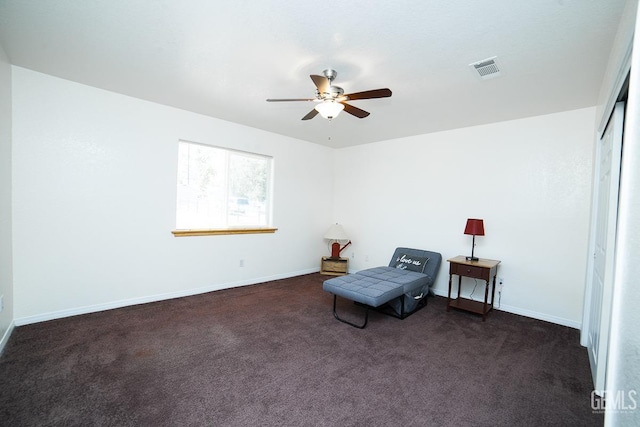 sitting room featuring dark colored carpet and ceiling fan