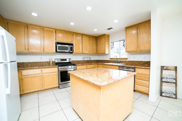 kitchen featuring sink, stainless steel appliances, light tile patterned floors, light stone counters, and a kitchen island