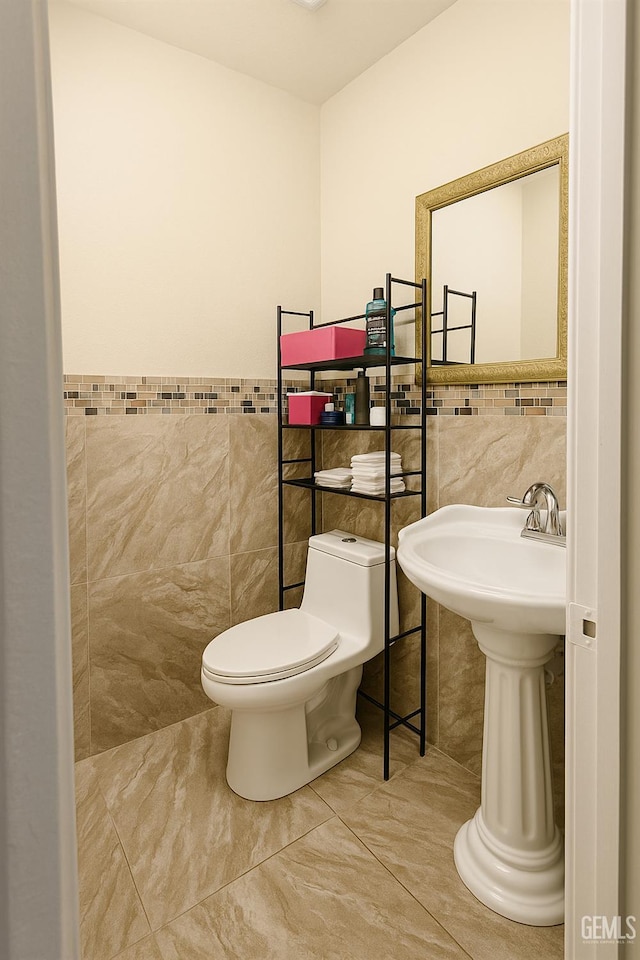 701 Burnett Dr, Bakersfield, CA 93307 - bathroom with tile walls, toilet, tile patterned flooring, and wainscoting