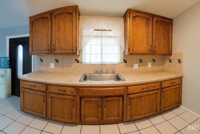 701 Burnett Dr, Bakersfield, CA 93307 - kitchen with a sink, backsplash, brown cabinetry, and tile countertops