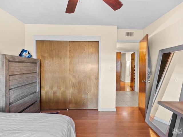 bedroom featuring hardwood / wood-style flooring, ceiling fan, and a closet