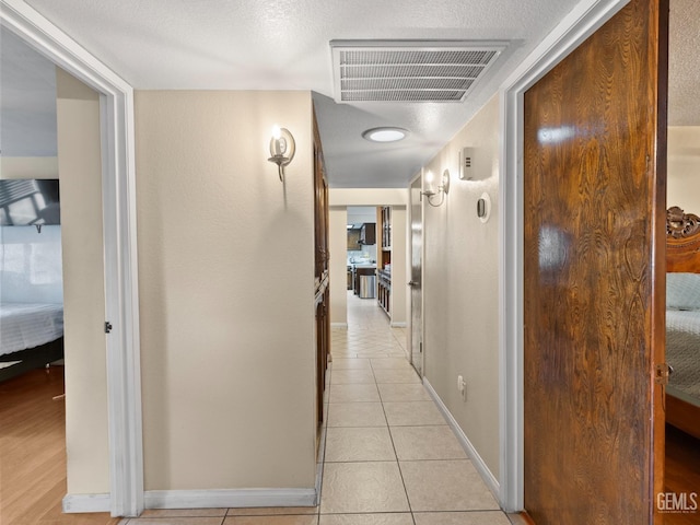 hall with light tile patterned floors