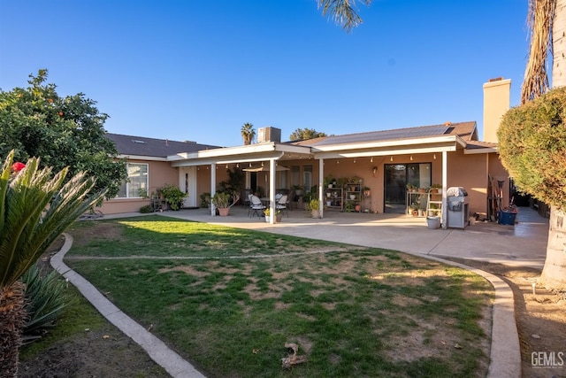 rear view of property with a yard and a patio area